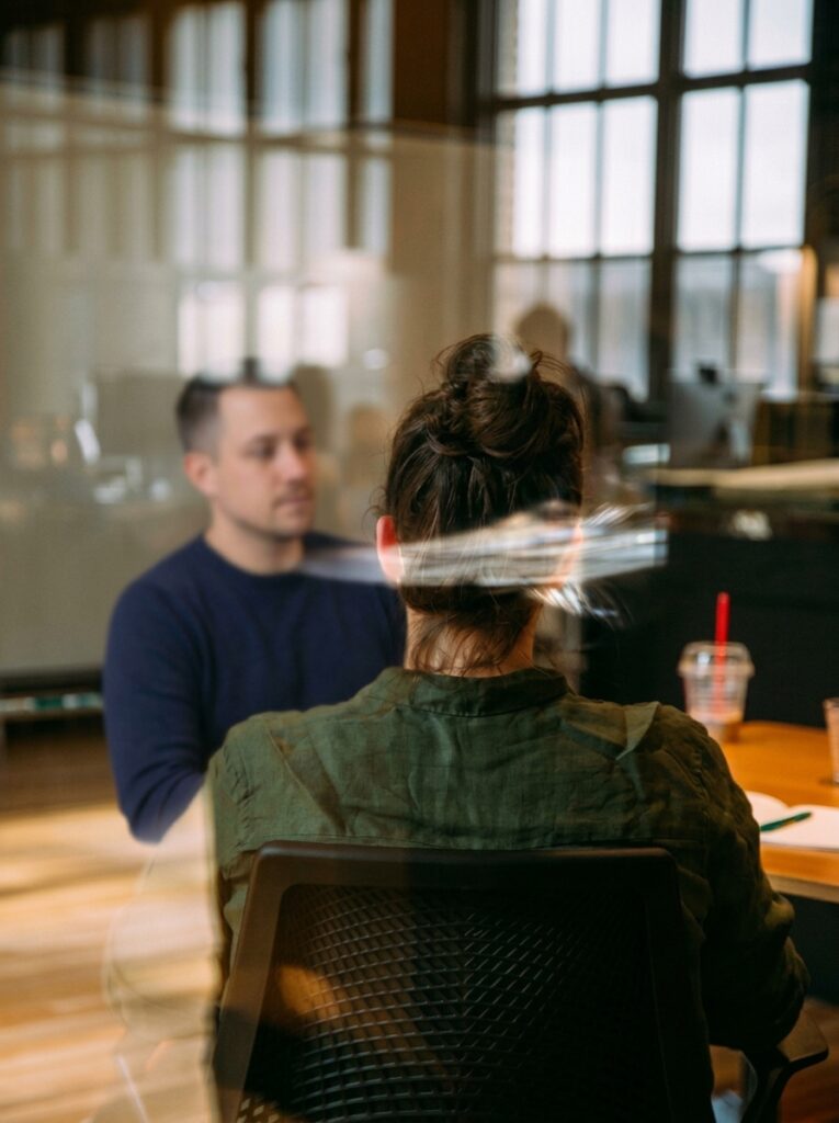 Unternehmensberater im persönlichen Kennenlerngespräch mit einer Kundin im Büro zur gemeinsamen Strukturierung von Projekten und Planung der Umsetzung