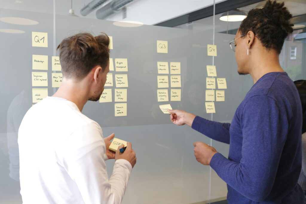 Projektteam plant Aufgaben und Meilensteine am Kanban-Board im klassischen Projektmanagement