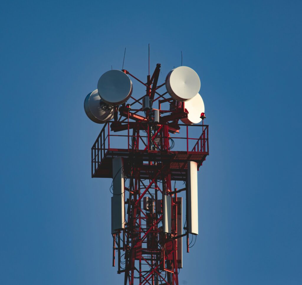 Telekommunikationsmast mit Richtfunkantennen und Wartungsplattform beim Ausbau kritischer Telekommunikationsinfrastruktur