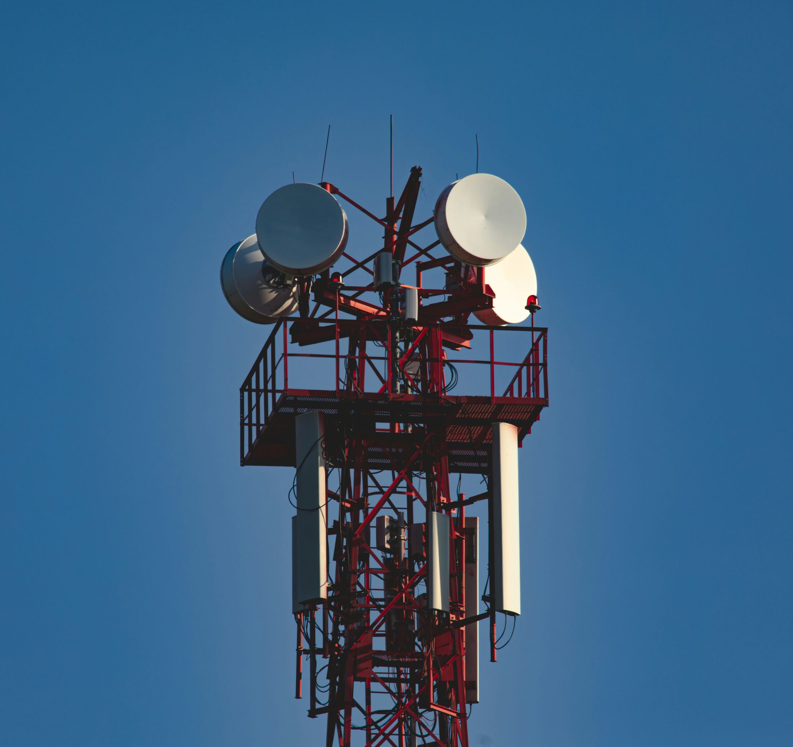 Telekommunikationsmast mit Richtfunkantennen und Wartungsplattform beim Ausbau kritischer Telekommunikationsinfrastruktur