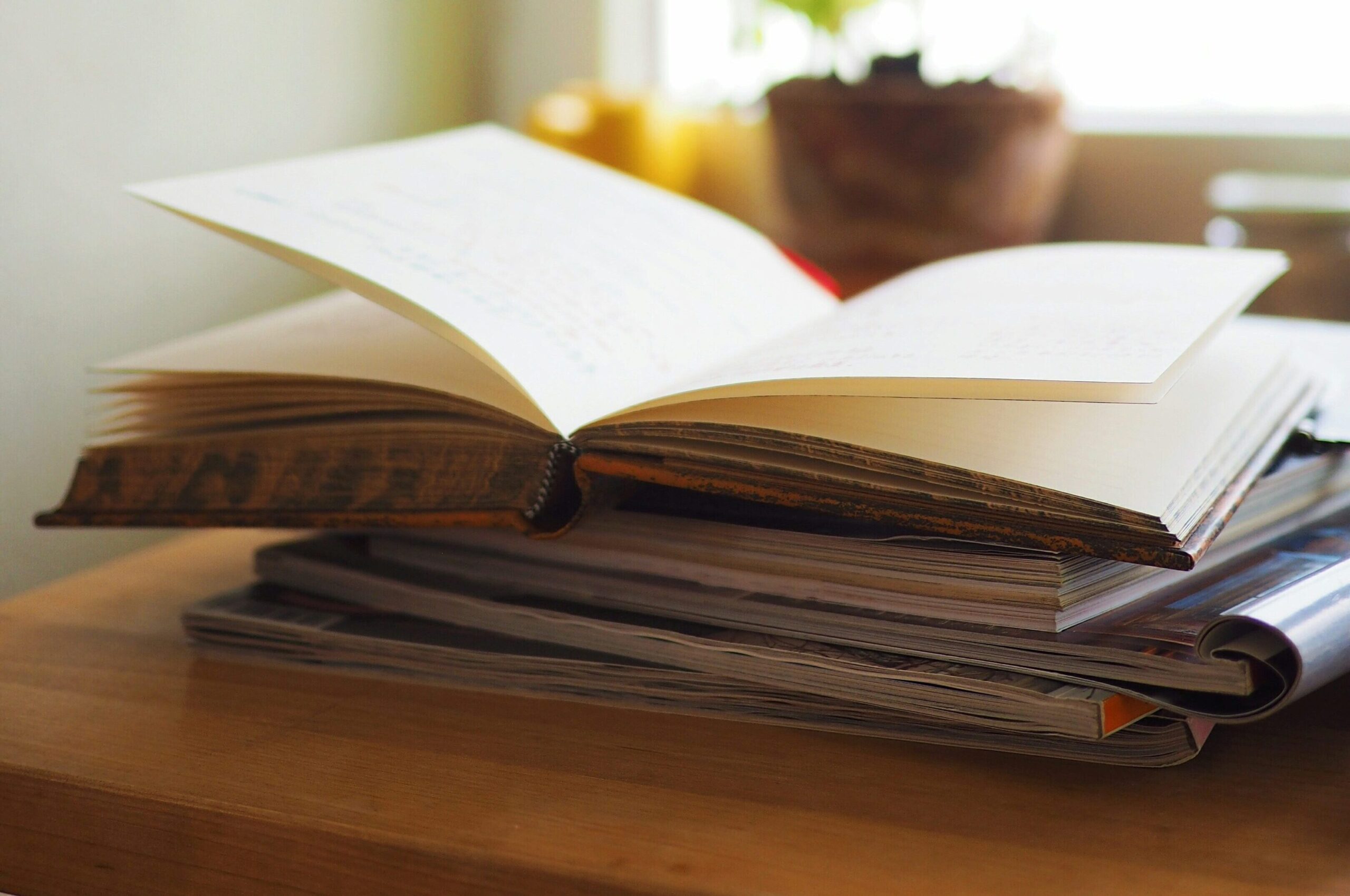 Aufgeschlagenes Buch auf einem Tisch als Symbol für Projektmanagement-Wissen, PMO-Begriffe und Methoden aus dem Projektalltag